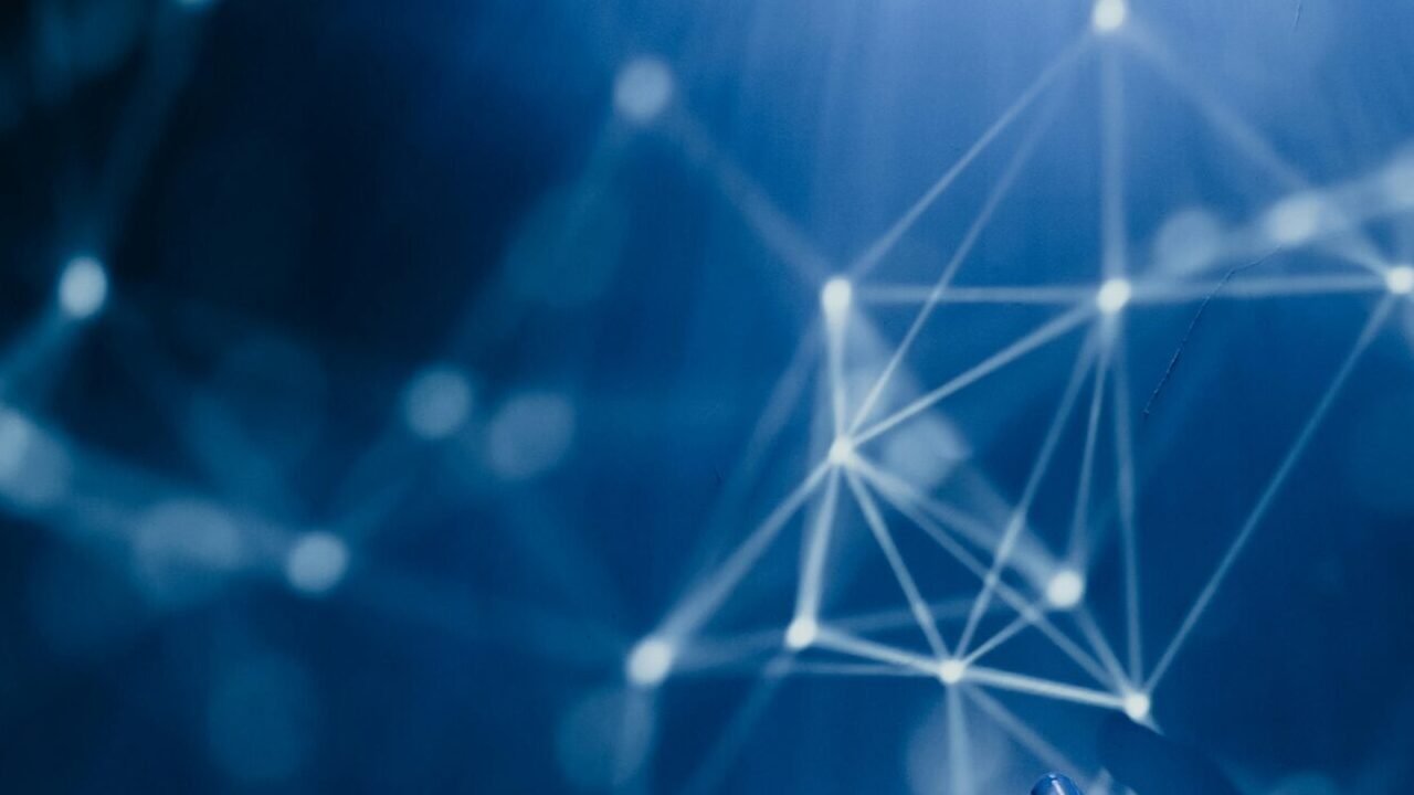 A robotic hand reaching into a digital network on a blue background, symbolizing AI technology.